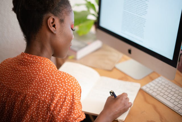 person in an orange shirt working in their home office